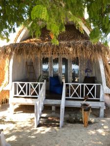 Une cabane de chaume avec un banc devant elle dans l'établissement La Bohème, à Gili Air