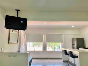 a living room with a kitchen with two chairs and a tv at 5th Av Studio Close to the Beach ADO Ferry & Mall in Playa del Carmen