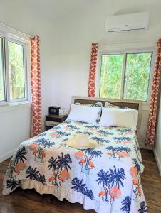 1 dormitorio con 1 cama con colcha azul y naranja en West Bay Roatan - Sunny & Modern Oasis- 2 Bedrooms - 3 min walk to beach, en Roatan