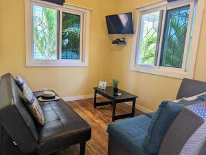 a living room with a couch and a table at West Bay Roatan - Sunny & Modern Oasis- - 3 min to beach - Queen beds! in Roatán