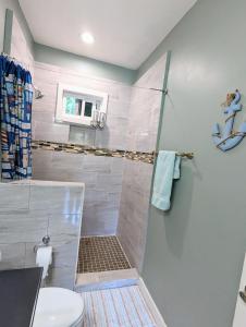 a bathroom with a shower and a toilet at West Bay Roatan - Sunny & Modern Oasis- 2 Bedrooms - 3 min walk to beach in Roatán