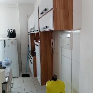 uma pequena cozinha com um objecto amarelo no primeiro plano em Apartamento no vila Olímpia mobiliado em Feira de Santana