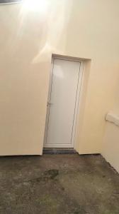 una puerta en la esquina de una habitación con una pared en DÉPENDANCE EN CHAMBRE D'HÔTE AVEC JACUZZI PRIVATIF DANS LA CHAMBRE v, en Amblainville