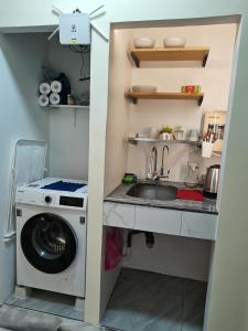 uma pequena cozinha com uma máquina de lavar roupa e um lavatório em Ampang Hilir KL City Boutique Residence em Kuala Lumpur