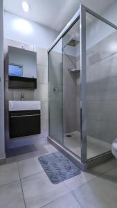 a bathroom with a glass shower and a sink at Riviera Home - New 2BR Condo w. big Pool & Jacuzzi in Playa del Carmen