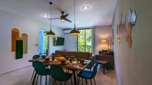 a dining room and living room with a table and chairs at Riviera Home - New 2BR Condo w. big Pool & Jacuzzi in Playa del Carmen