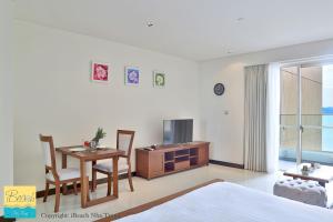 a bedroom with a bed and a table and a tv at Studio With SeaView in Nha Trang