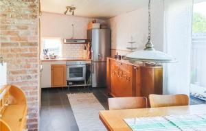 コスタにあるAmazing Home In Kosta With Wifiのキッチン(ステンレス製の冷蔵庫、テーブル付)