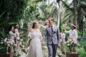 une mariée et un marié se promenant dans l'allée à leur mariage dans l'établissement Adiwana Unagi Suites, à Ubud