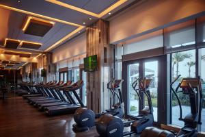 a gym with a row of treadmills and elliptical machines at The Ritz-Carlton, Haikou in Haikou