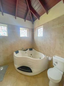 a bathroom with a bath tub and a toilet at Da-Vis By The Ocean in Saint Philip