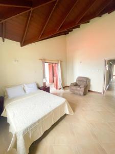 a large bedroom with a bed and a chair at Da-Vis By The Ocean in Saint Philip