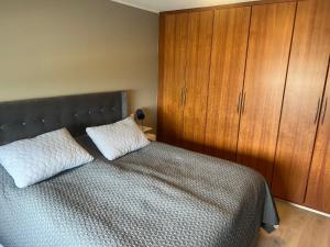 1 dormitorio con 1 cama y armario de madera en Eskivellir en Hafnarfjördur