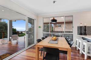 a kitchen and dining room with a wooden table and chairs at Del Boca Vista in Emerald Beach