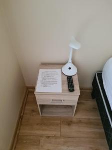 a nightstand with a lamp on it next to a bed at Excelente departamento en Las Condes in Santiago