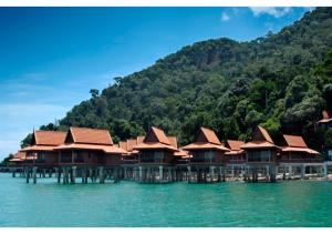 eine Reihe von Häusern auf einem Dock im Wasser in der Unterkunft Berjaya Langkawi Resort in Pantai Kok
