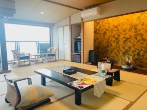 a living room with a coffee table and a couch at Syukaen Yunohanazen in Atami