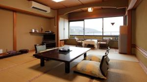 a living room with a table and a dining room at Syukaen Yunohanazen in Atami