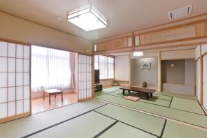 um quarto vazio com uma mesa e janelas em Onsen Hotel Nakahara Bessou Nonsmoking, Earthquake retrofit em Kagoshima