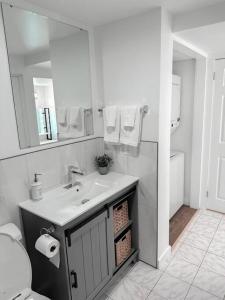 Baño blanco con lavabo y espejo en The Victoria Suite in Elora- King Bed en Elora