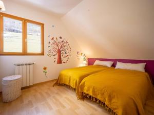 um quarto com uma cama amarela e um mural de árvore na parede em Maison Génos-Val Louron, 5 pièces, 10 personnes - FR-1-695-26 em Génos