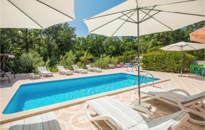 una piscina con sedie e ombrelloni e una piscina di Stunning Home In Porec With Kitchen a Poreč (Parenzo)