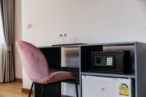 a pink chair sitting in front of a desk with a microwave at Casa Luna in Bangkok