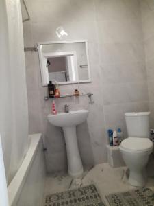a bathroom with a sink and a toilet and a mirror at Квартира ЖК Балкадиша in Promyshlennyy