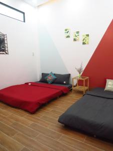 twee bedden in een kamer met een rode en witte muur bij HO GIA AN Home - Double Room in Can Tho