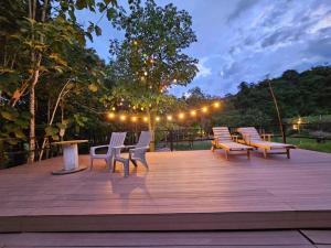 a group of chairs sitting on a wooden deck at night at Tuku, in Guarinocito