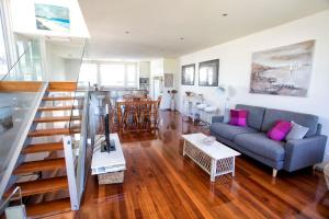 a living room with a couch and a staircase at BELLA CASA in Queenscliff