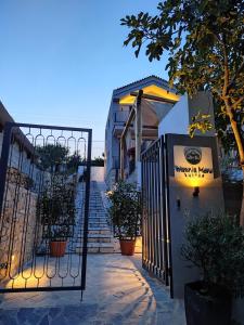 een poort naar een gebouw met potplanten en trappen bij Trizonia Mare Suites in Trizonía