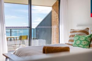 a bedroom with a bed and a large window at Namanula 7 - oceanstays in Yamba