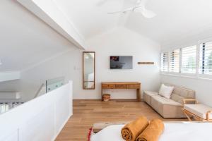 a white living room with a couch and a table at Namanula 7 - oceanstays in Yamba