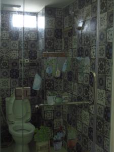 La salle de bains est pourvue de toilettes et d'une douche en verre. dans l'établissement HO GIA AN Home - King Room, à Ấp Lợi Ðủ