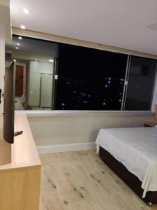 a bedroom with a large window with a view of a city at 20º Andar Vista Linda Próx a Santa Casa, UFRGS - BnB Serviços Inteligentes Por Fioravante in Porto Alegre