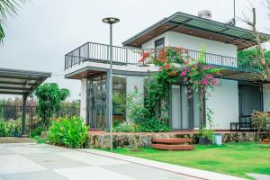 una casa con un balcón con flores. en Hana Villa Long An, en Long An