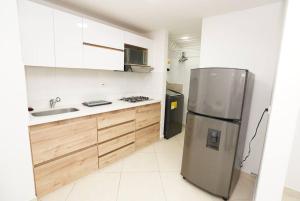 cocina con nevera de acero inoxidable y fregadero en Apartamento Medellin-sabaneta a cuadra del metro, en Sabaneta