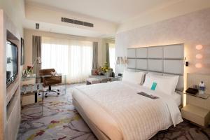 a hotel room with a large bed and a desk at Le Meridien Gurgaon, Delhi NCR in Gurgaon