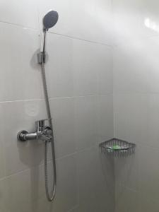 een douche met een douchekop in de badkamer bij Tamansari Homestay in Sawan
