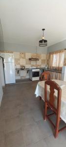 eine Küche mit einem Tisch und einem Kühlschrank in der Unterkunft ANELEY Casa De Vacaciones in La Merced