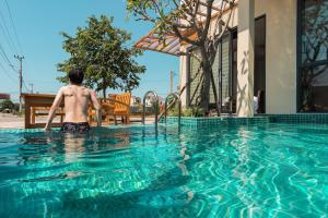 a man is standing in a swimming pool at Basil Boutique Villa by Class6 in Hoi An