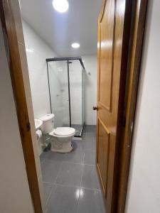 a bathroom with a toilet and a glass shower at Linving buenos aires in Medellín