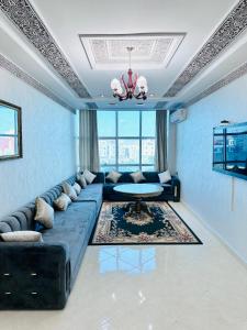 - un salon avec un canapé bleu et une table dans l'établissement Abraj Dubai Larache, à Larache