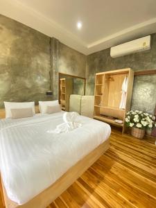 1 dormitorio con 1 cama blanca grande en una habitación en เพลินนะเพลินนารีสอร์ท en Ban Rim Lao
