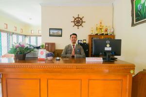 a man sitting at a desk with a computer at OYO 1667 Edotel Smkn 1 Pacet Syariah in Puncak