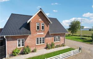 a red brick house with a black roof at Nice Home In Christiansfeld With House Sea View in Christiansfeld