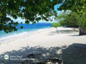 a beach with a tree and the ocean at Peaceful and Romantic Country Home in Kabalwa