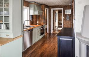 a kitchen with white cabinets and a wooden floor at Cozy Home In Dagali With House A Mountain View in Dagali