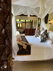 a child sitting on a bed in a bedroom at Subak Tabola Villa in Sidemen